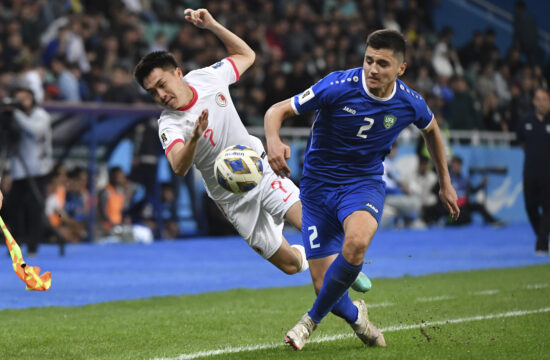 Hong Kong's Yu Joy Yin Jessie, left, challenges for the ball with Uzbekistan's Abdukodir Khusanov during the second round of the Asian qualifier group E soccer match for 2026 FIFA World Cup between Uzbekistan and Hong Kong at the Bunyodkor stadium in Tashkent, Uzbekistan, Tuesday, March 26, 2024. (AP Photo)